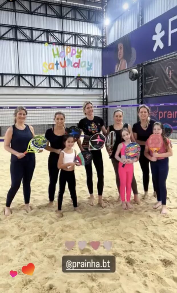 O Segredo da União: 5 Atividades de Beach Tennis para Pais e Filhos 2 Mães e filhas, sorridentes e usando roupas de esporte vibrantes da jogando beach tennis